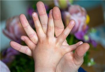 Eine Mutter hält die Hand ihrer Tochter.
