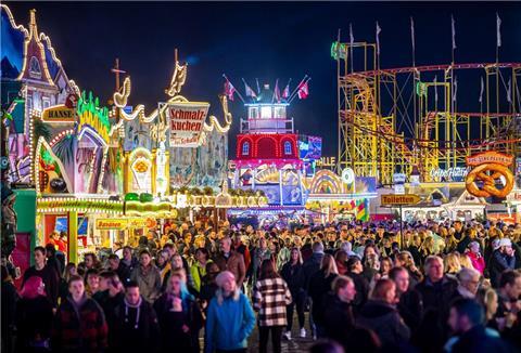 Die Fahrgeschäfte auf dem Freimarkt auf dem Bürgerweide leuchten mit bunten Lichtern und Reklameschriftzügen