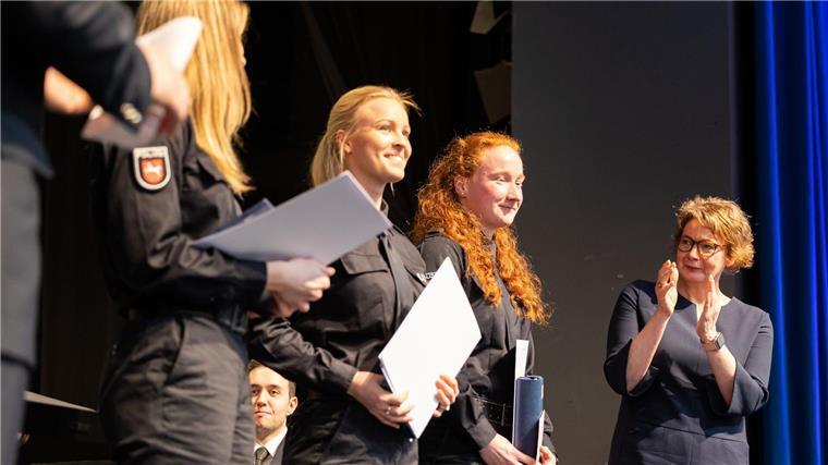 Niedersachsen hat 169 neue Polizeikommissare Daniela Behrens (SPD, r), Innenministerin Niedersachsen, steht neben Absolventen und Absolventinnen der Polizeiakademie.