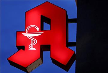 Das Apotheken-Logo leuchtet an einer Apotheke.