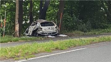 Ein Auto steht nach einer Kollision zerstört im Seitenrand einer Straße.