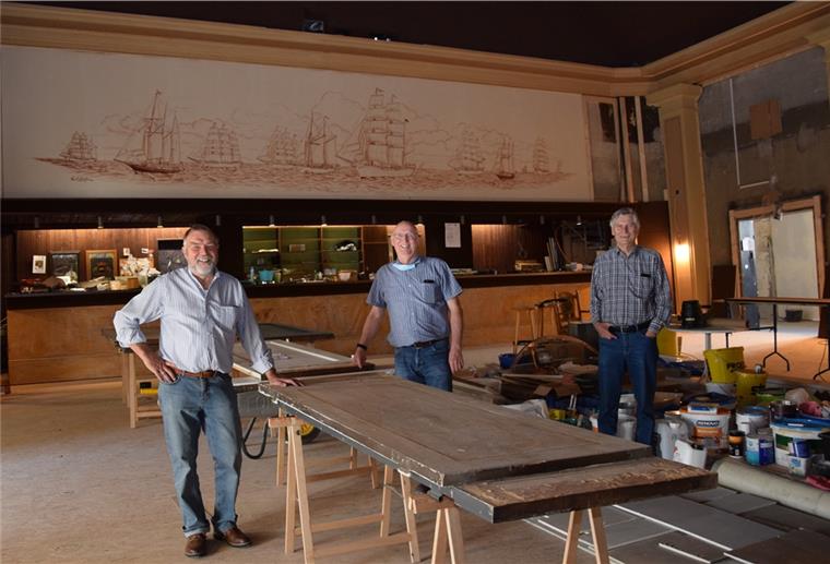 CTB: Neue Bespannung in alter Farbe Das Bild über der Bar ist bislang während der Bauarbeiten im Kinosaal verhängt gewesen, damit es keinen Schaden erleidet. Jetzt freuen sich Jan Kuilert, Norbert Ostendorf und Jens Frost (von links), dass die Schutzmaßnahmen Erfolg hatten.