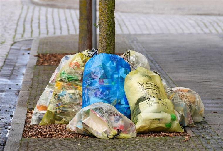 Neue strenge Abfall-Regel: Das darf nicht mehr in den Bio-, Rest- und Sondermüll Müll in gelben Säcken liegen am Straßenrand, mittendrin liegt ein blauer Müllsack.