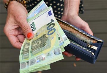 Eine Frau hält eine mit mehreren Geldscheinen gefüllte Geldbörse in einer Hand, darunter Hundert-, Fünfzig- und Zwanzig-Euro-Scheine. Das Klimageld soll eine Entlastung für die Deutschen bringen. Doch die Auszahlung steht noch aus.
