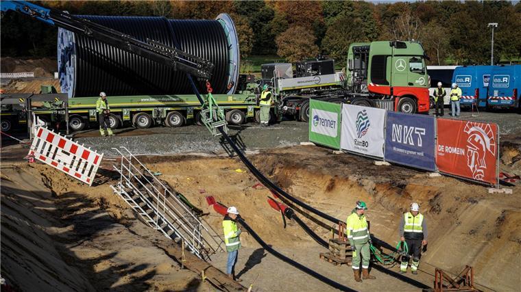 Bau der Trasse Suedlink - Vier Kabel für die Energiewende Das Erdkabel wird mit einem Schwertransporter geliefert und mit Hilfe einer Seilwinde in den Graben gehoben.