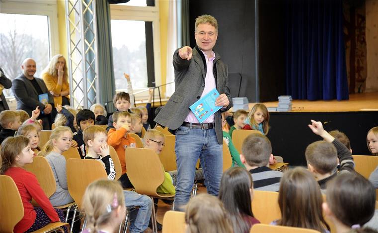 Werder-Star unterstützt Grundschüler beim Lesen Das erste Buch wird von Marco Bode in der Gaußschule 1 überreicht. Foto Scheschonka