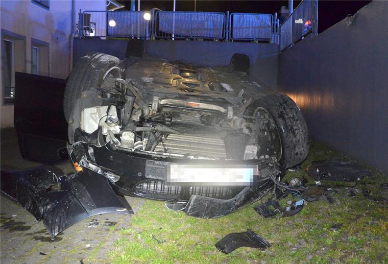 BMW durchbricht Metallzaun und stürzt zwei Meter in die Tiefe Das Fahrzeug blieb nach dem Unfall auf dem Dach liegen. Der Fahrer wurde nur leicht verletzt.