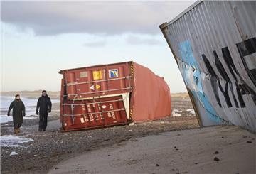 Menschen gehen an gestrandeten Containern in der Gegend zwischen Tranum und Slette Strand vorbei.