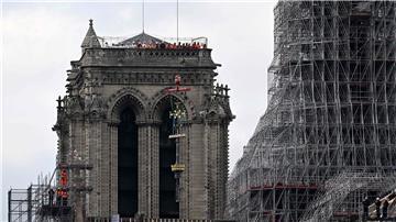 Das Kreuz der Kathedrale Notre-Dame wird während des Wiederaufbaus auf die neu errichteten Turmspitze gesetzt.