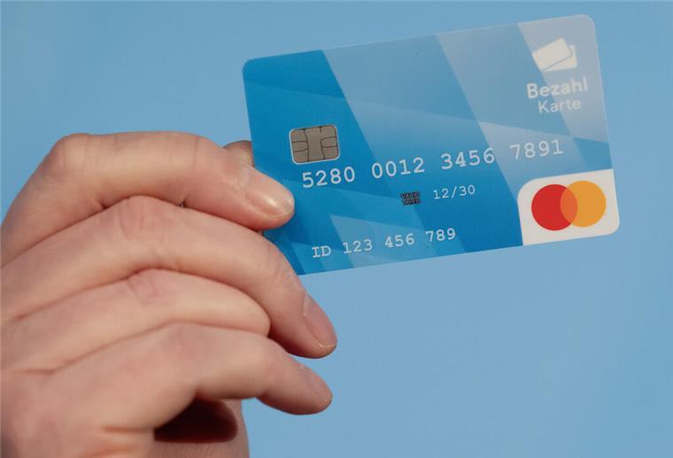 Bezahlkarte: Grantz-Kritik wegen unterschiedlich viel Bargeld für Flüchtlinge Ein Mann hält während einer Pressekonferenz eine Bezahlkarte in der Hand.