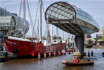 Das sanierte Feuerschiff „Elbe 3" passiert auf seinem Weg von der Bredo-Werft bis zum Liegeplatz im Museumshafen des Deutschen Schifffahrtsmuseums in Bremerhaven auch die Havenwelten, muss durchs Nadelöhr zweier Klappbrücken und der aufgeschwenkten Glasbrücke vorbei am Klimahaus.