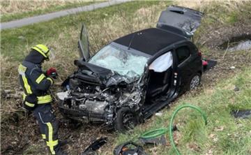 Ein zerstörtes Auto liegt auf einem Grünstreifen