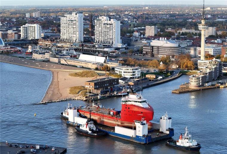 Offshore-Versorger kehrt huckepack nach Bremerhaven zurück Ein Ponton, beladen mit einem Schiff, vor der Skyline Bremerhavens.
