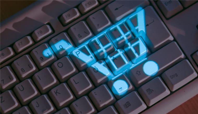 Neue Bezahl-Regeln für Käufe im Internet Das Symbol eines Einkaufskorbs leuchtet auf einer Computertastatur (gestelltes Foto).