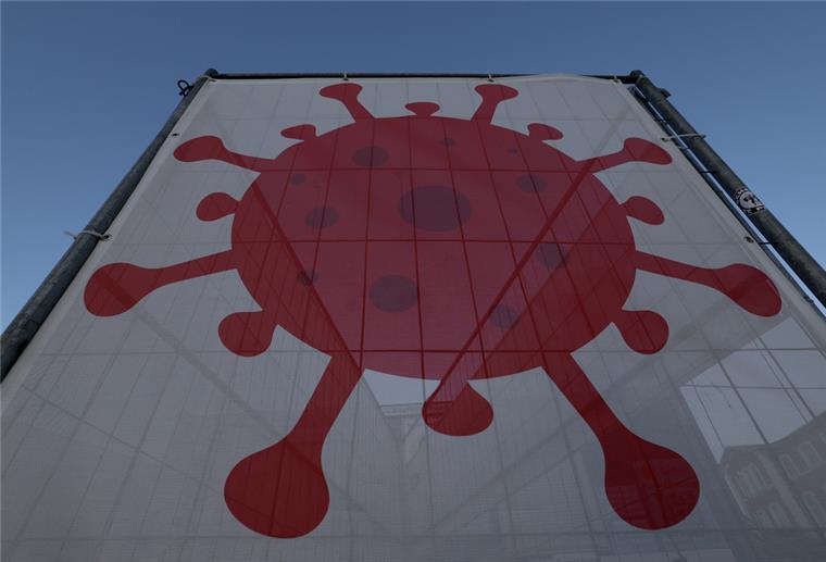 Das Symbol für einen Corona-Virus hängt an der Teststation.