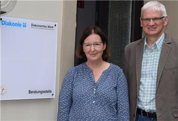 Ein Mann und eine Frau vor einer Beratungsstelle.