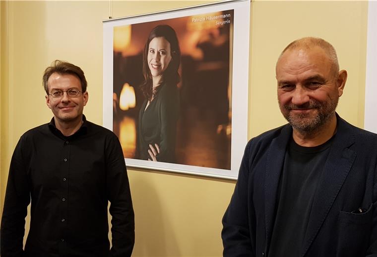 Das Team der "Tragédie de Carmen" – Generalmusikdirektor Marc Niemann (links) und Regisseur Matthias Oldag – steht vor dem Porträt von Patrizia Häusermann, die die Carmen singt.