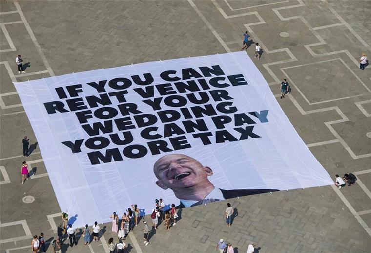 Das Transparent zeigt ein Foto des Amazon-Gründers, auf dem steht: „If you can rent Venice for your wedding you can pay more tax“.
