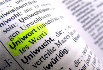 Die Seite eines Wörterbuches, das Wort Unwort ist gelb makiert. 