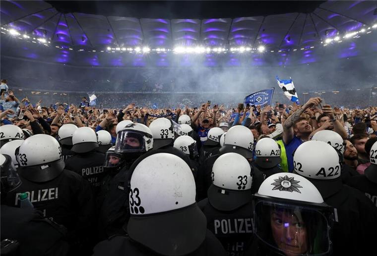 44 Verletzte beim HSV-Aufstieg – ein Fan in Lebensgefahr Polizisten stehen vor HSV-Fans, die nach dem Spiel den Rasen gestürmt haben.