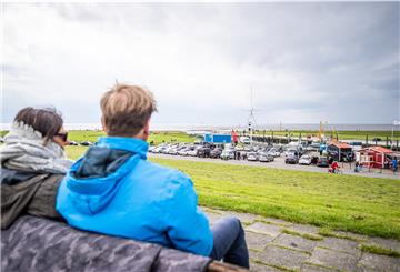 Das wechselhafte Wetter machte vielen nichts aus: Der Wremer Kutterhafen ist eines der beliebten Ziele am Pfingstsonntag gewesen, an den Buden herrschte reger Betrieb. Foto: Hartmann