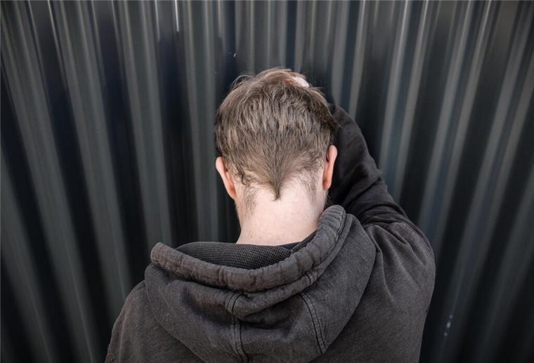 Von Schlafmangel zu Burnout – Schadet die Arbeit der Gesundheit? Ein fässt sich an den Kopf und steht mit dem Rücken zur Kamera.
