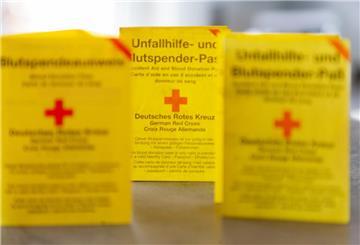 Drei Blutspendeausweise auf einem Tisch.