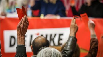 Delegierte heben bei einer Abstimmung auf einem Landesparteitag der Partei Die Linke ihre Stimmkarten.