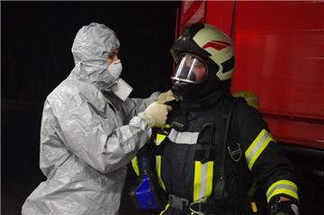 Dem Feuerwehrmann wird das Atemschutzgerät von Mitstreitern aus Bad Bederkesa oder Lintig entfernt. Diese Ortswehren sind nach größeren Einsätzen für die Einhaltung und Abwicklung der Einsatzhygiene zuständig.