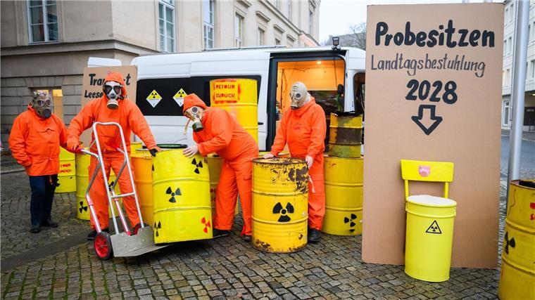 Initiative fordert Ende von Atommüll-Zwischenlager Leese Demonstranten der Bürgerinitiative Strahlenschutz Leese stehen mit künstlichen Atommüllfässern vor dem niedersächsischen Landtag.