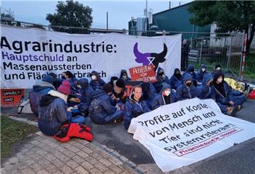 Demonstranten sitzen bei einer unangemeldeten Protestaktion vor einem Betrieb des Schlachtkonzerns Tönnies.