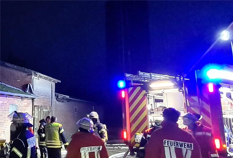Feuerwehrleute stehen hinterm Einsatzfahrzeug