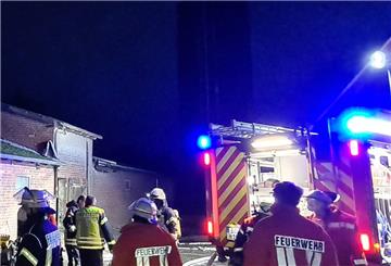 Feuerwehrleute stehen hinterm Einsatzfahrzeug