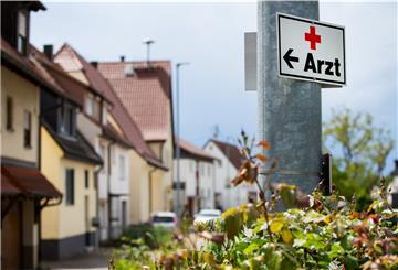 Ein Schild mit der Aufschrift «Arzt» hängt an einer Straßenlaterne.