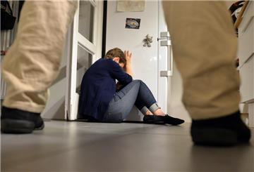  Gestelltes Bild zum Thema häusliche Gewalt - Eine Frau versucht, sich vor der Gewalt eines Mannes zu schützen. 
