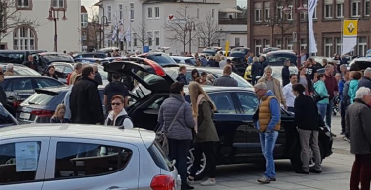 Interessierte Besucher schauen sich Autos auf dem Nordenhamer Markplatz an