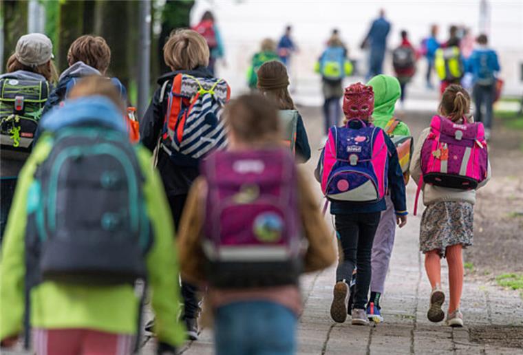 Immer mehr Schüler in der Gemeinde Schiffdorf Kinder mit Schultaschen gehen auf einem Fußweg.