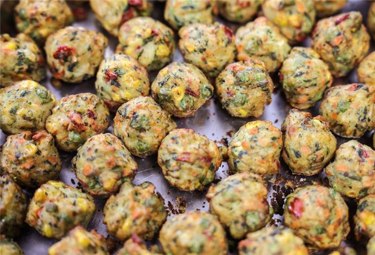 Kirche spricht über Bauern-Protest gegen vegetarisches Essen Vegetarische Gemüsebällchen liegen in auf einem Blech.