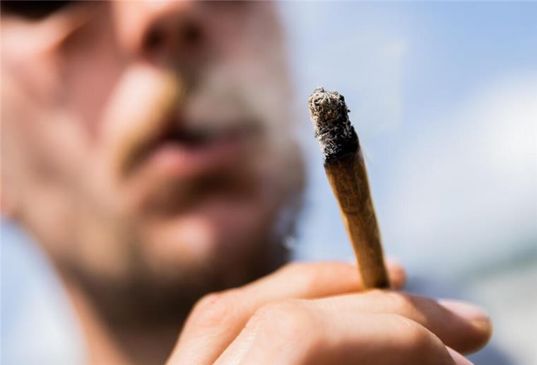 Die Grünen wollen Bremen zur Modellregion für Cannabis-Verkauf machen Ein Mann raucht einen Joint