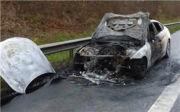 Ein ausgebranntes Fahrzeug steht auf dem Seitenstreifen einer Autobahn.