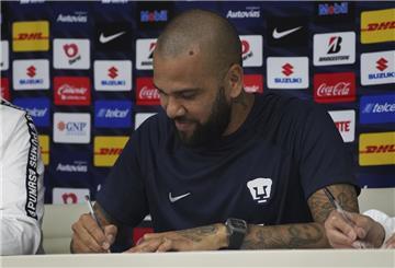 Der brasilianische Fußballer Dani Alves unterschreibt einen Vertrag während einer Pressekonferenz, auf der er als neues Mitglied des Fußballvereins Pumas UNAM vorgestellt wurde. 