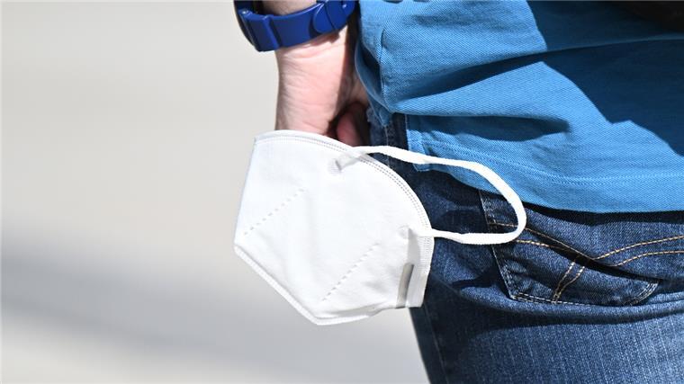Virologe: Corona-Mehrfachinfektionen sind gefährlicher Ein Mann trägt eine Maske in der Hand.