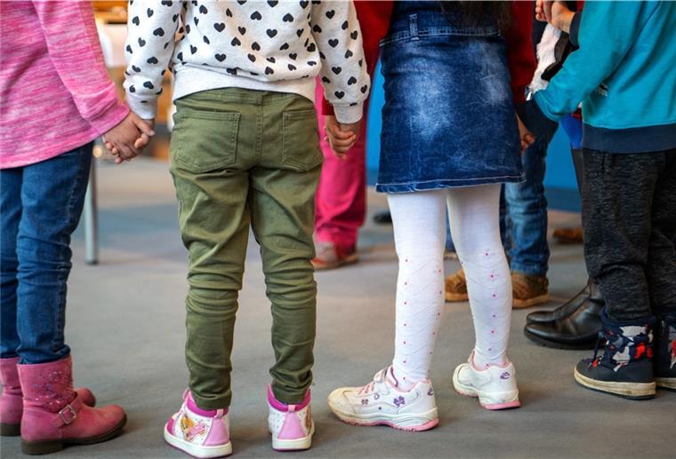 Bremerhaven setzt Kita-Beitragspflicht aus Kinder im Kindergartenalter stehen nebeneinander und halten sich an den Händen.