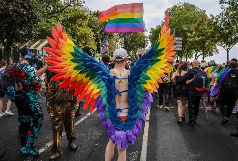Bremen feiert den CSD: Über 18.000 Teilnehmende erwartet Ein Teilnehmer des Christopher Street Day (CSD) trägt regenbogenfarbene Flügel.