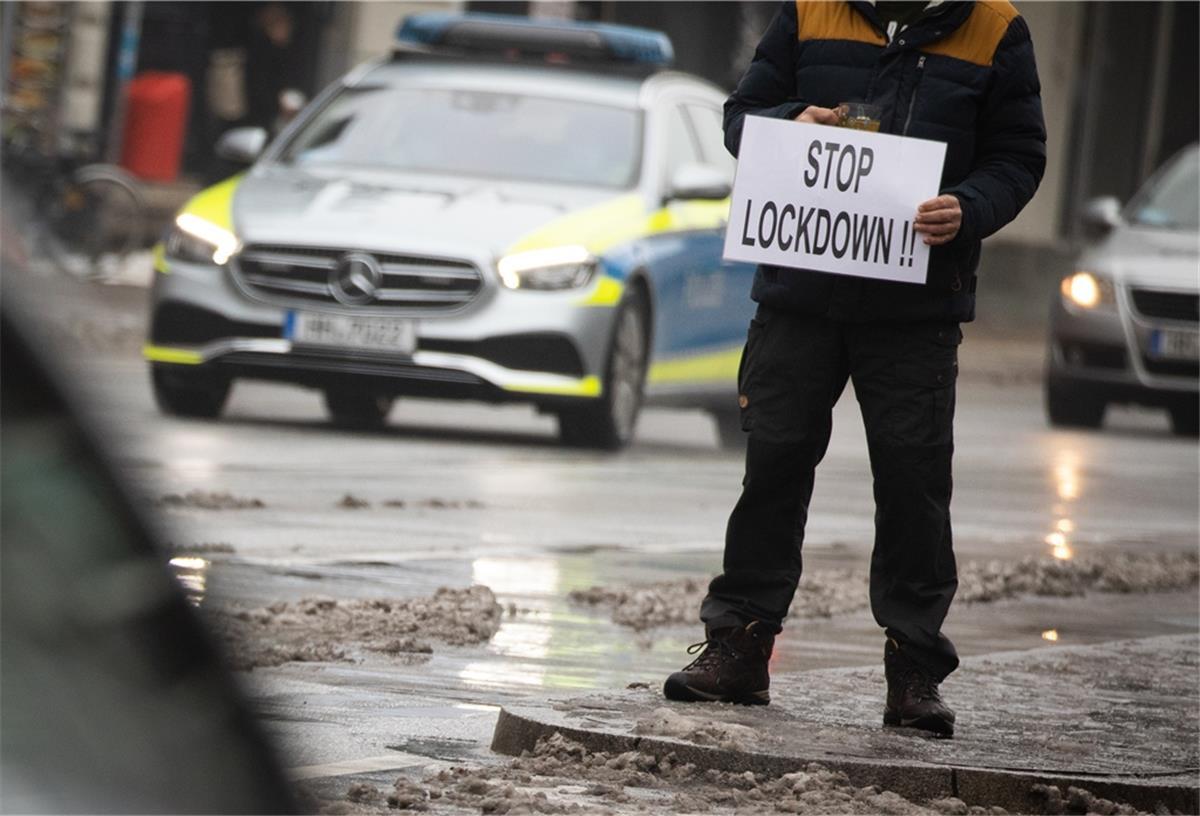 Corona-Lockdown wird verlängert Ein Mann hält ein Schild mit der Aufschrift "Stop Lockdown!!" während einer spontanen Demonstration nach einer Durchsuchung bei einem Arzt.