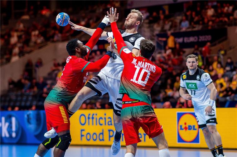 Handball: Deutschland wird Fünfter bei der EM Der deutsche Spieler Julius Kühn (Mitte) setzt sich gegen Alexis Borges (links) und Miguel Martins aus Portugal in Szene. Rechts David Schmidt aus Deutschland.