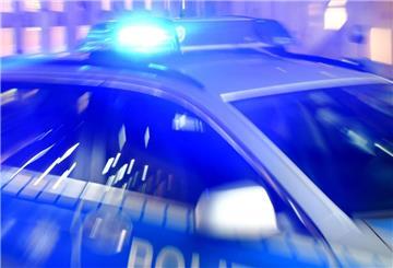 Ein Streifenwagen der Polizei steht mit eingeschaltetem Blaulicht auf der Straße.