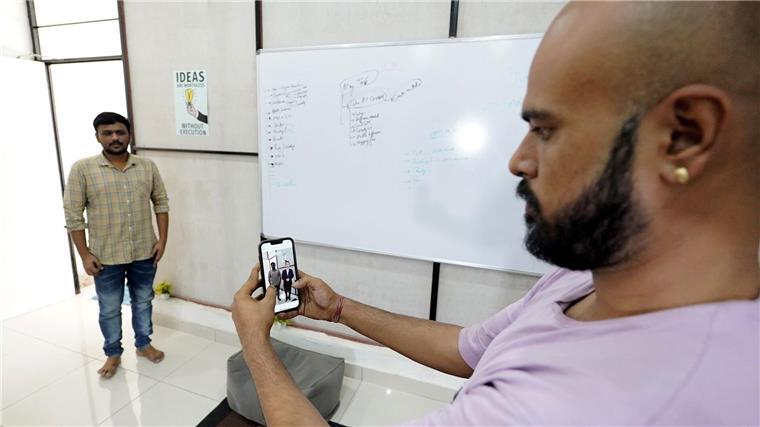 Der Eigentümer der Firma Polymath Synthetic Media Solutions, Divyendra Singh Jadoun, demonstriert mit einem Kollegen wie Leute Selfies mit Politiker-Avataren in ihrer gewohnten Umgebung machen können.
