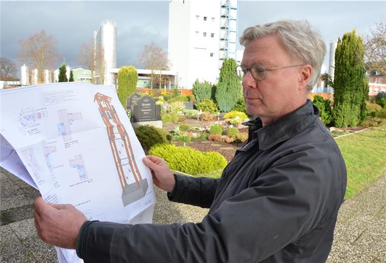 Elsdorf: Glockenturm neben der Friedhofskapelle geplant Der Elsdorfer Pastor Michael Grimm steht mit der Zeichnung des geplanten Glockenturms auf dem Friedhof. Der wird voraussichtlich Anfang kommenden Jahres gebaut. Im Hintergrund sind Gebäude der Molkerei zu sehen.