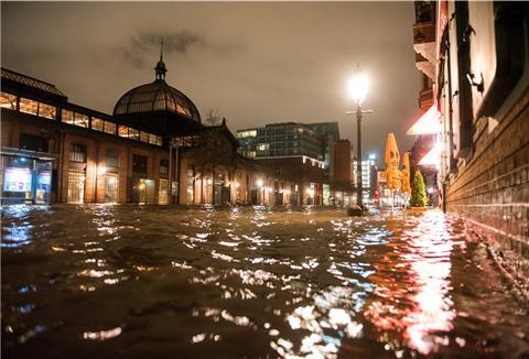 Die Straße am Fischmarkt mit der Fischauktionshalle an der Elbe steht während einer Sturmflut unter Wasser.